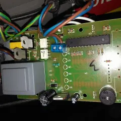 Sterownik Atos jak ustawić? Widok płytki drukowanej z elementami elektronicznymi, przewodami i przekaźnikiem.