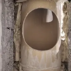 Otwór w ceramicznym kominie, przygotowany do dalszych prac. Widać izolację i fragmenty konstrukcji.