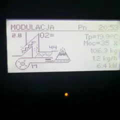 Wyświetlacz pieca Kostrzewa z ustawieniami: modulacja, O2, temperatura, moc, waga paliwa, podajnik i moc grzewcza. System fuzzy logic optymalizuje pracę.