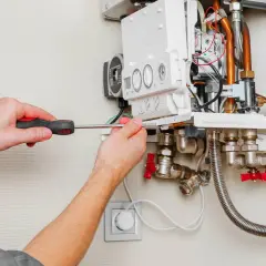 Serwisant naprawia kocioł Immergas, który wyświetla błąd E43. Widoczne są przewody, zawory i narzędzia.
