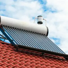 Kolektor słoneczny na dachu do grzania wody. Fotowoltaika w akcji, wykorzystująca energię słońca.