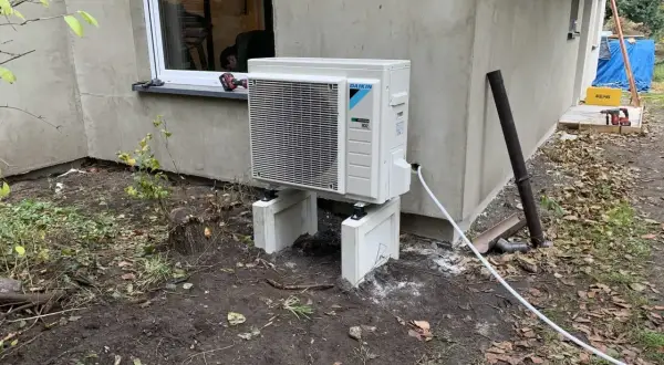 Nowoczesna pompa ciepła woda woda Daikin, zamontowana na zewnątrz budynku, gotowa do pracy.
