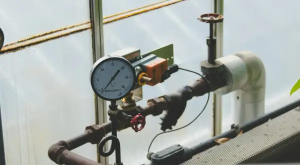 Manometr pokazuje ciśnienie w układzie zamkniętym. Rury i zawory są częścią instalacji.