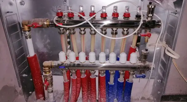 Rozdzielacz do sterowania ogrzewaniem podłogowym w każdym pokoju. System zapewnia komfort cieplny i oszczędność energii.