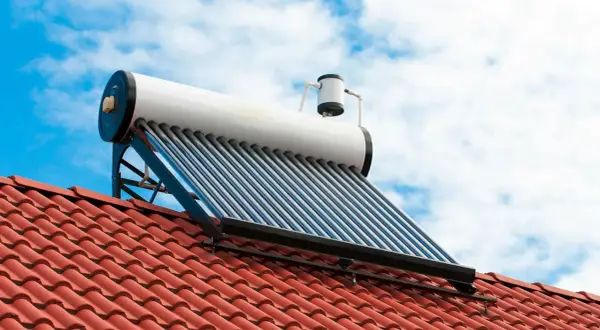 Kolektor słoneczny na dachu do grzania wody. Fotowoltaika w akcji, wykorzystująca energię słońca.