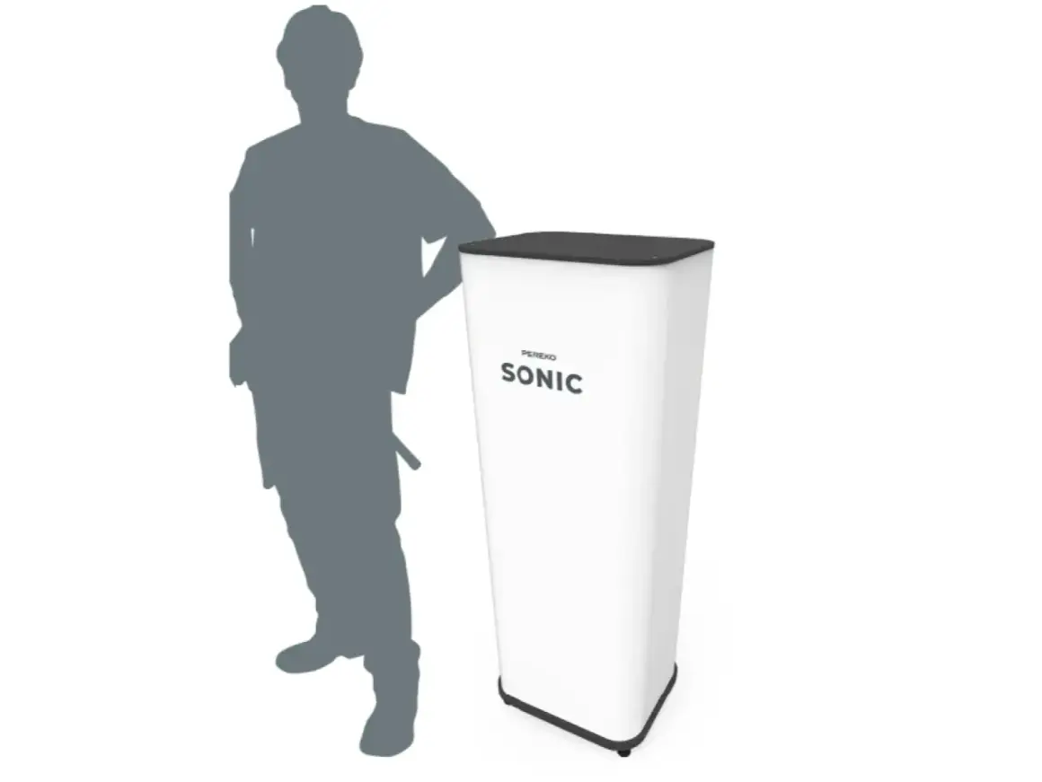 Stojący obok białego stoiska z napisem "SONIC" mężczyzna. Urządzenie może być wykorzystywane do prezentacji, a jego kocioł soniczny nie generuje dużego zużycia prądu.