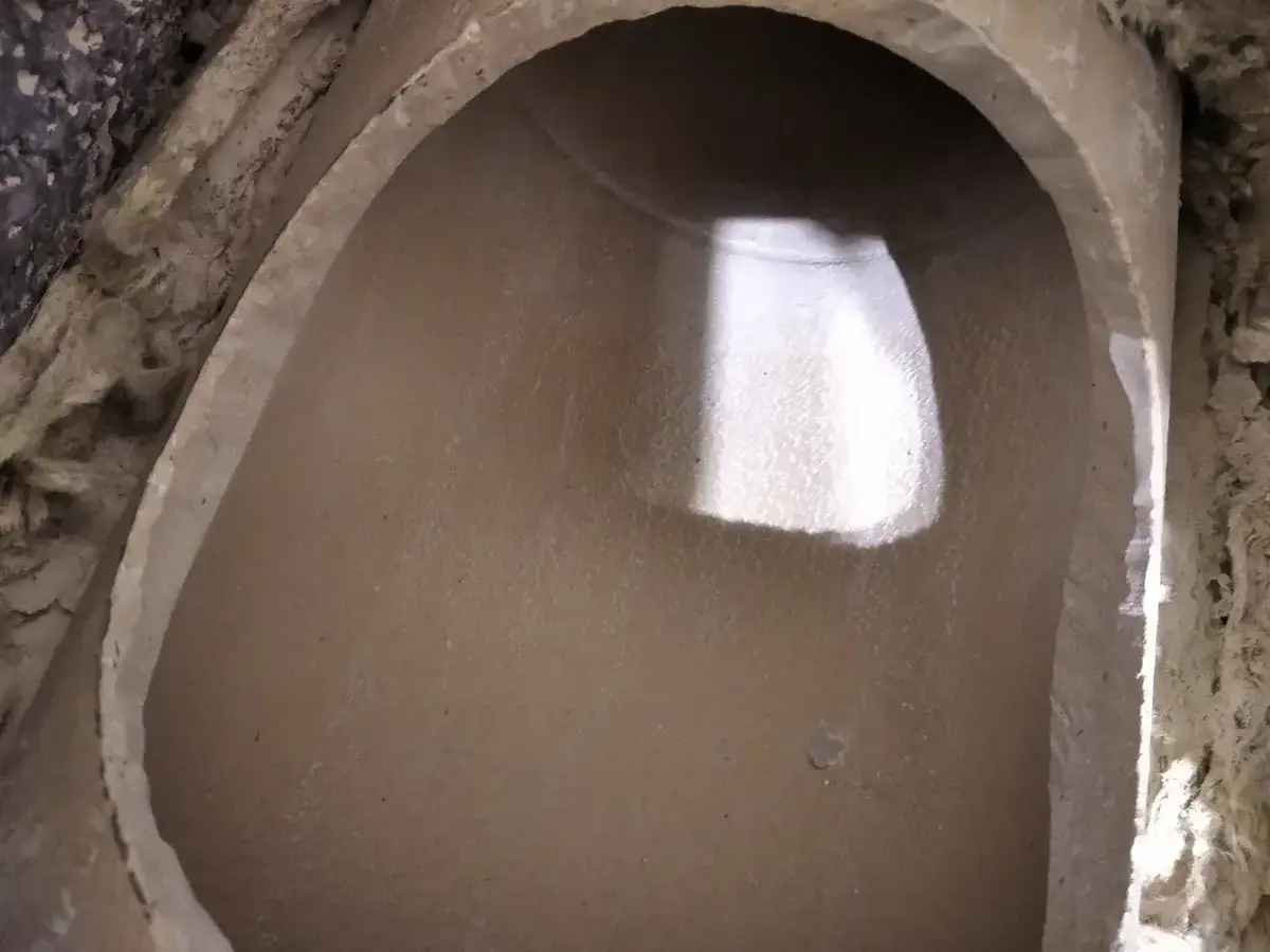 Widok wnętrza ceramicznego komina, gdzie widać świeżo wycięty otwór.