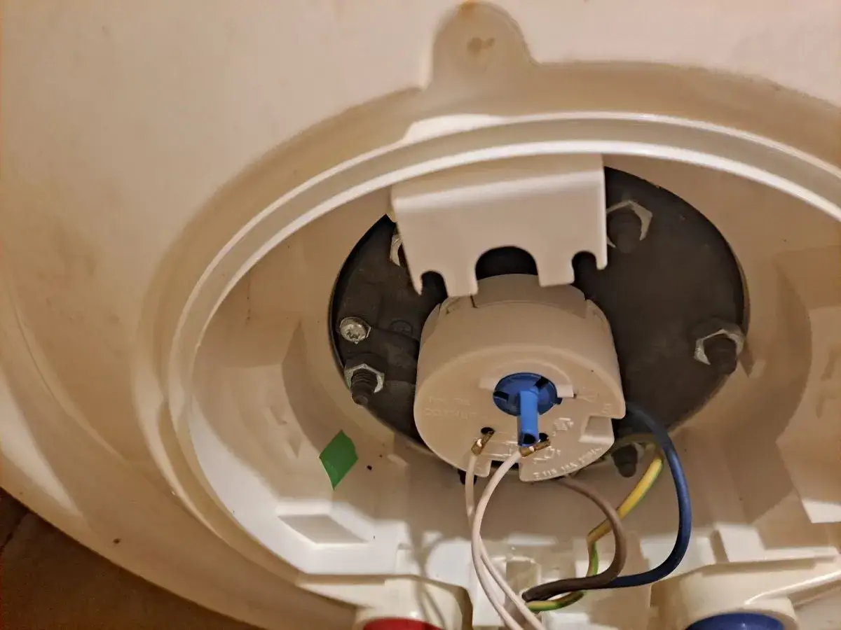 Regulator termostatu bojlera, który pozwala ustawić jaka temperatura wody w bojlerze będzie optymalna. Widać przewody i mocowania.